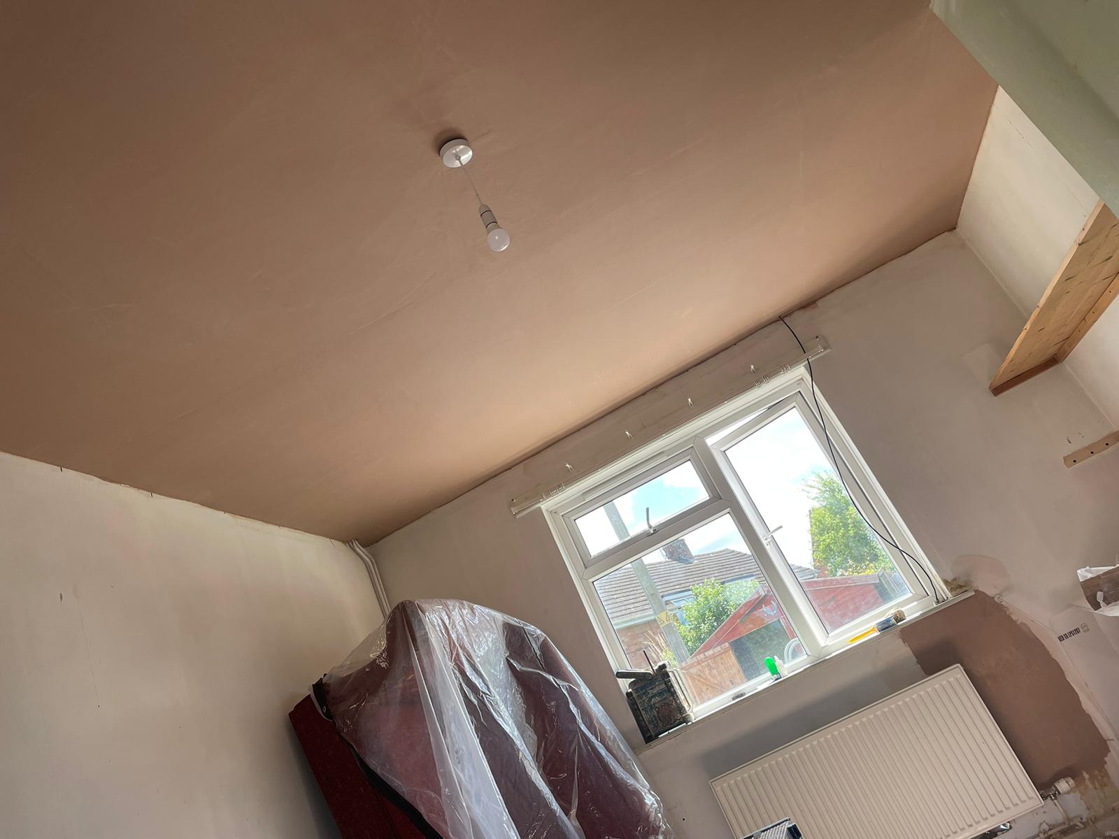 A bedroom with freshly plastered walls and ceiling