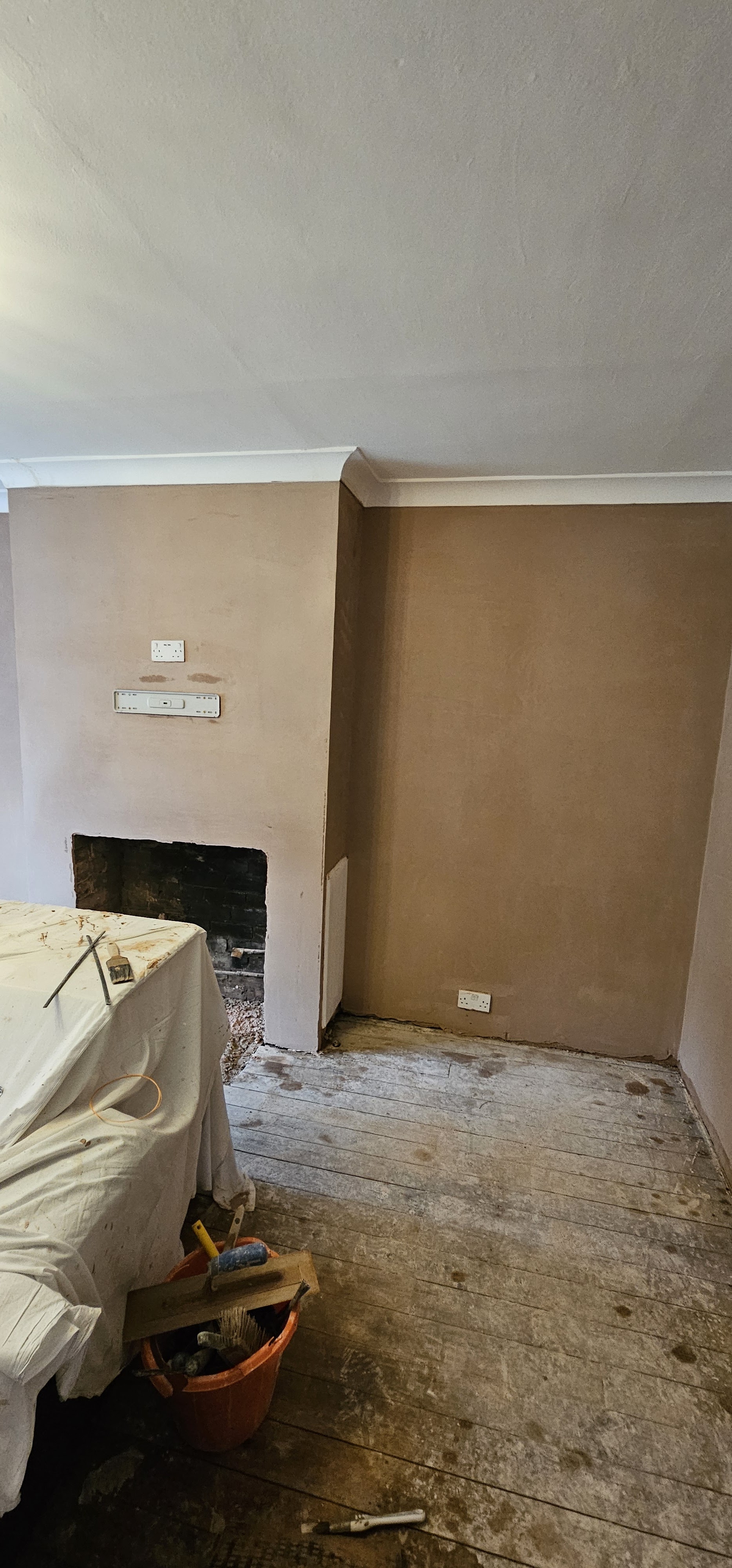 A room freshly plastered around the chimney breast, ready for decorating